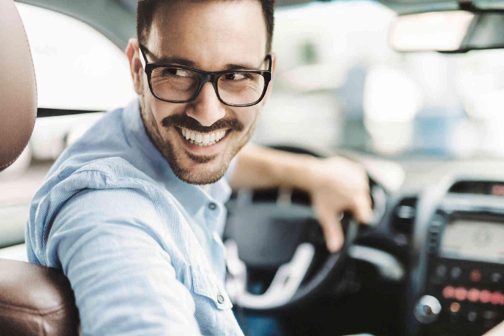 Man with glasses in the drivers seat