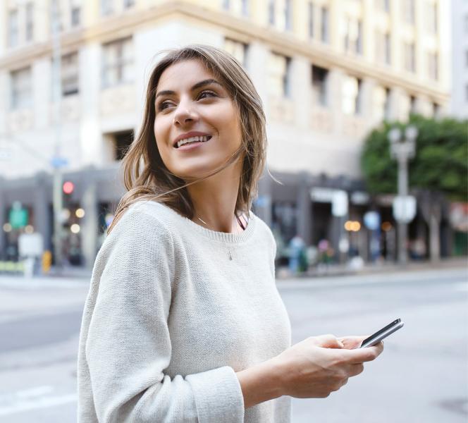 Frau mit Smartphone auf Straße
