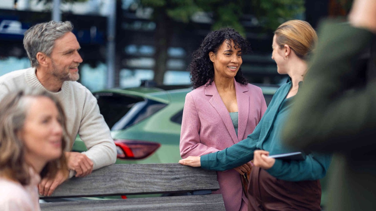 Gruppe steht um Sitzbank herum.