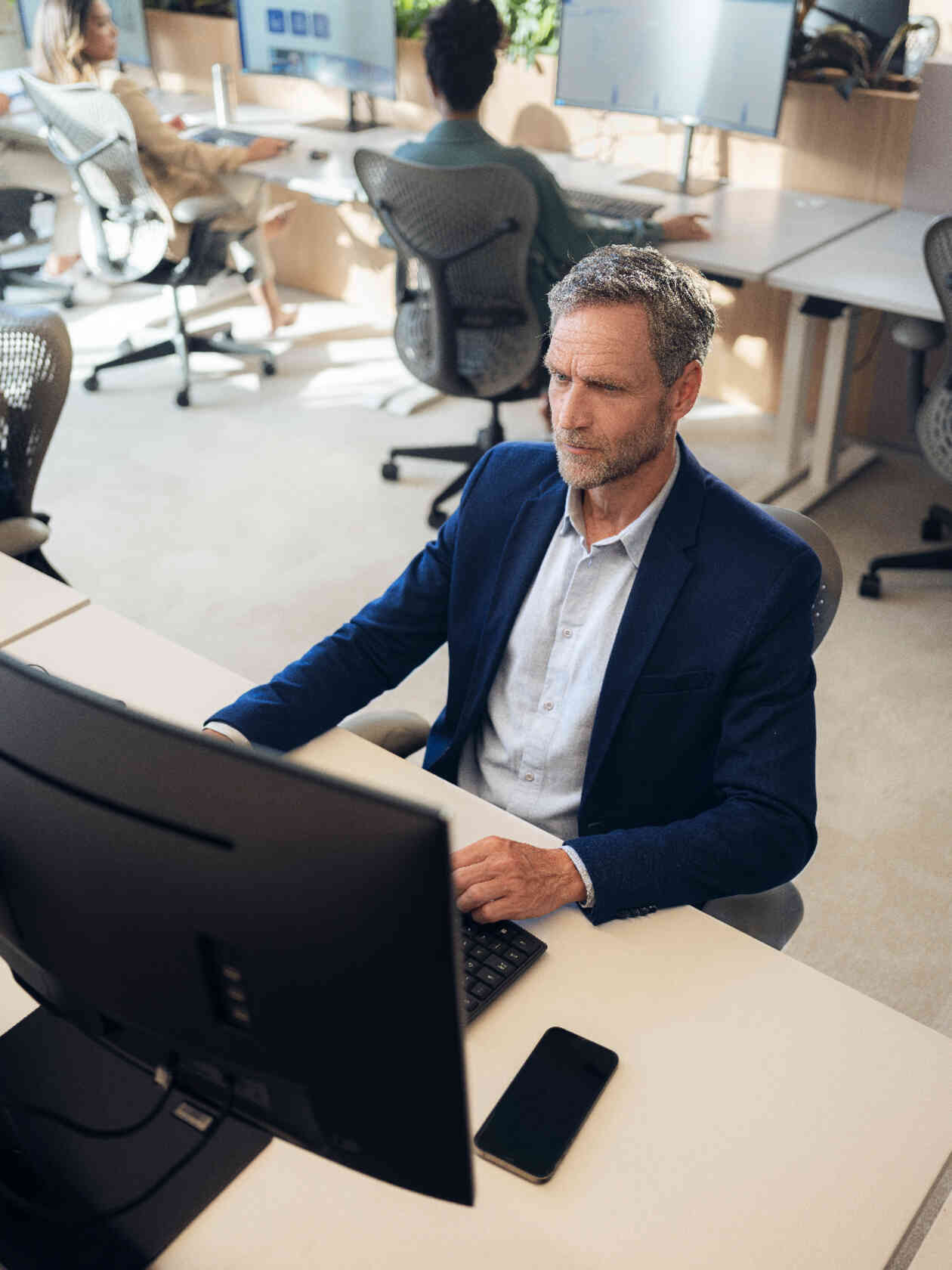 Mann im Anzug am Schreibtisch.