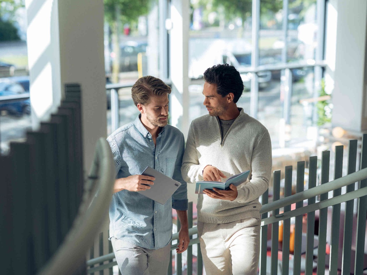 Zwei Maenner gehen Treppe hinauf.