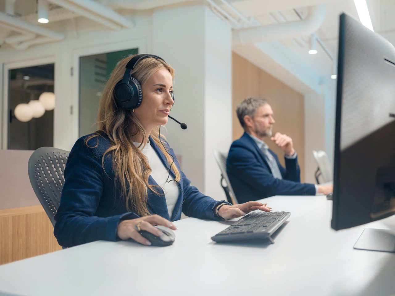 Personen mit Headsets in einem Büro.