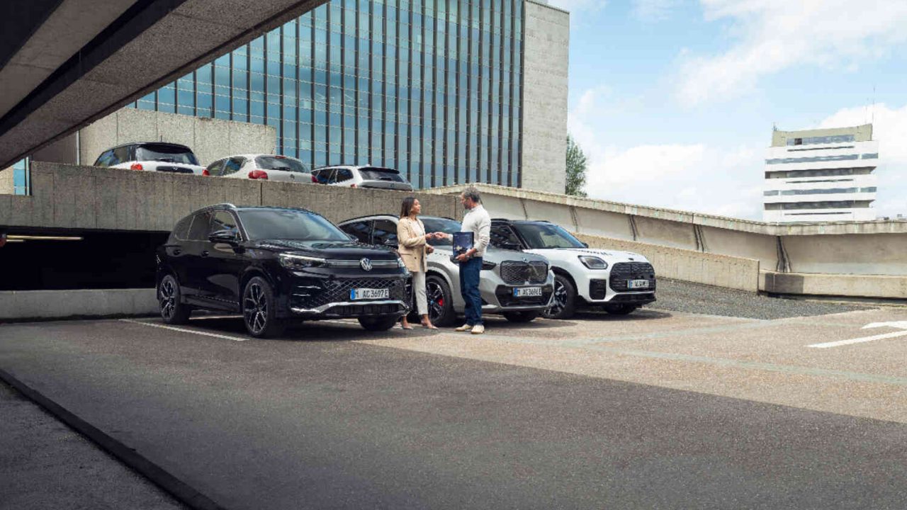 Zwei Personen neben Autos auf Parkdeck.