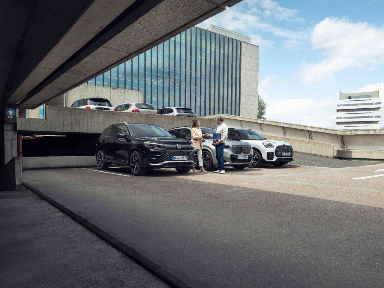 Zwei Personen neben Autos.