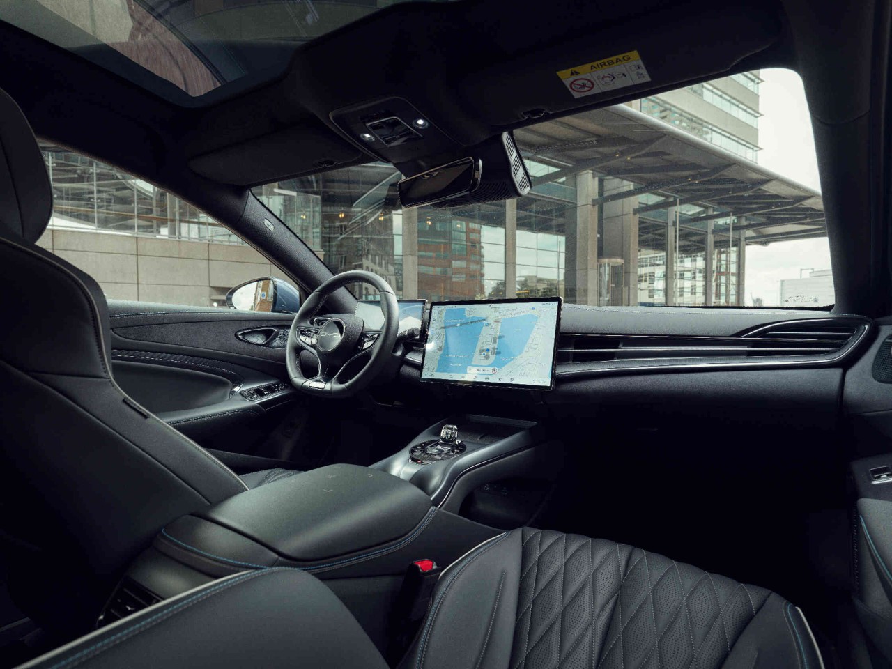 Ansicht auf die vordere schwarze Innenausstattung eines Fahrzeugs aus der Sicht des Beifahrers die Komfort und modernes Design zeigt.