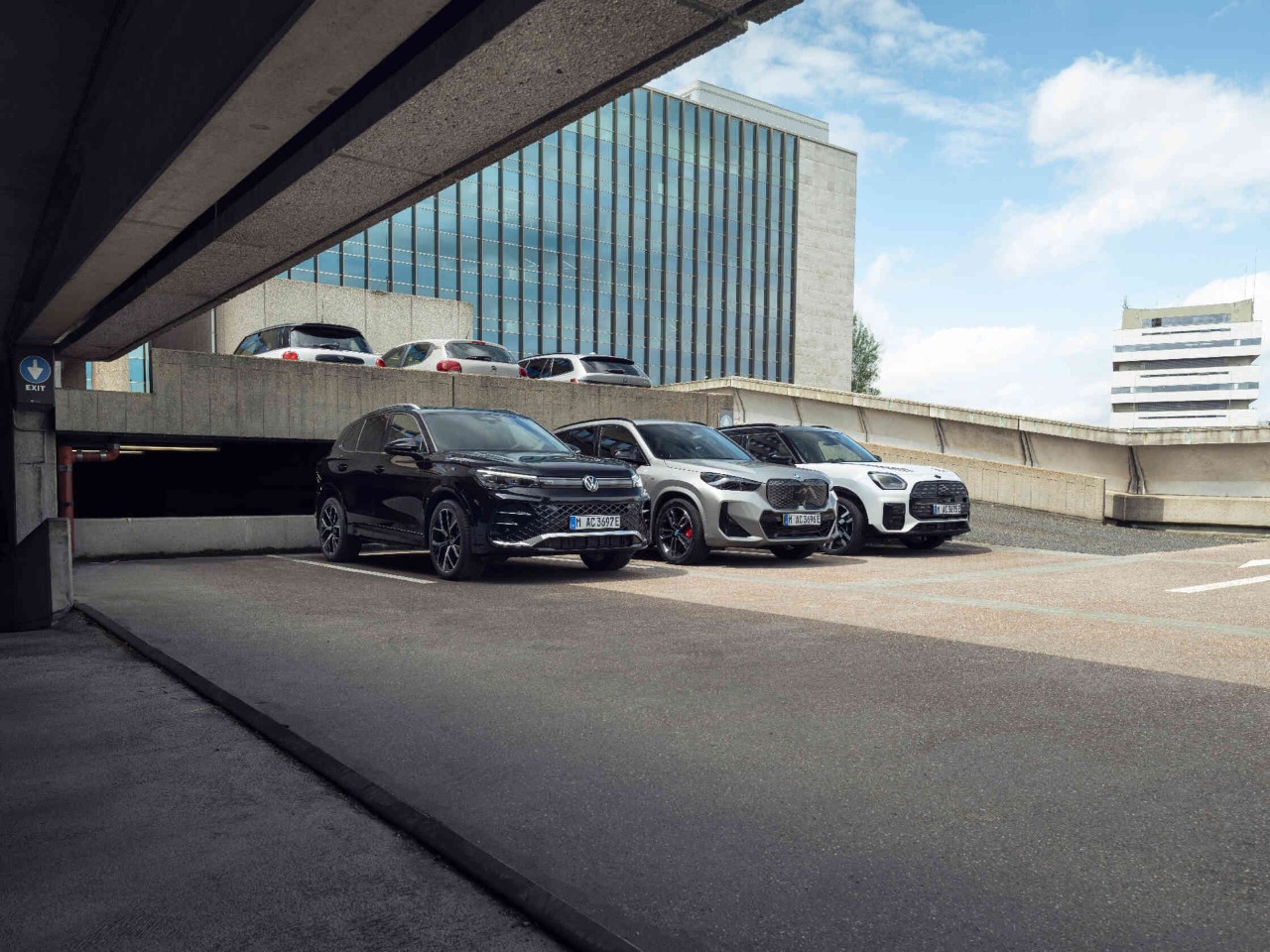 Drei Autos nebeneinander auf Parkplatz.