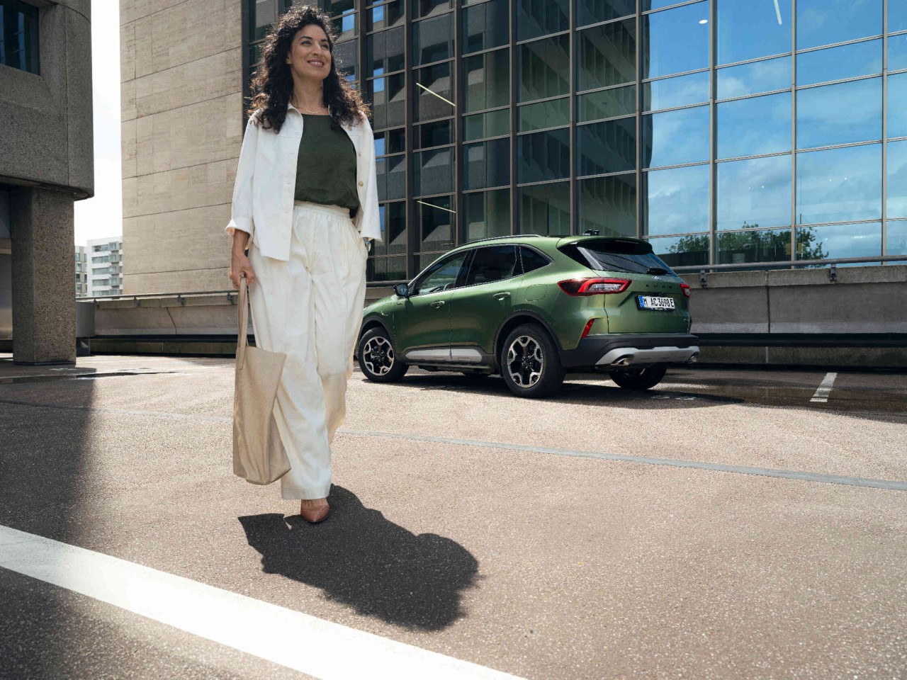 Gruener SUV auf Parkplatz.