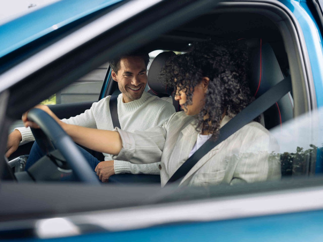 Frau im Auto am Steuer traegt Sicherheitsgurt.