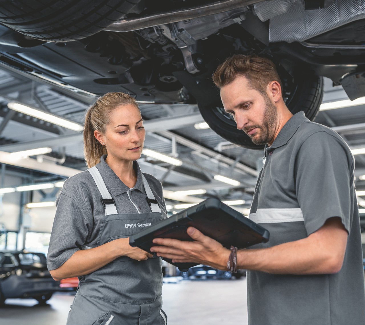 Frau und Mann stehen in der Werkstatt und schauen gemeinsam auf ein Geraet