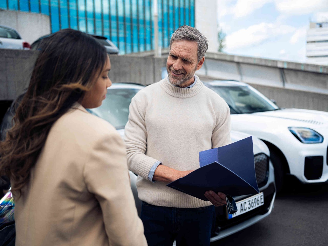 Mann haelt blaue Mappe.