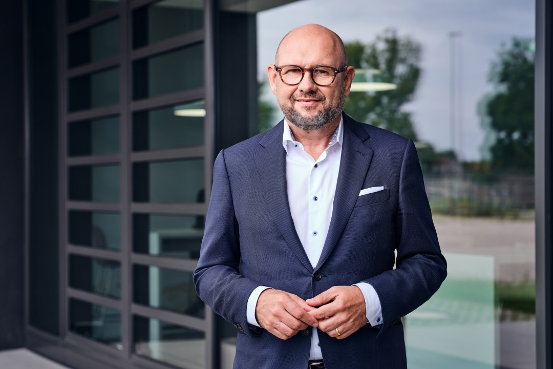 Portraitaufnahme von Alphbabet CEO Uwe Hildinger vor Glasfenster