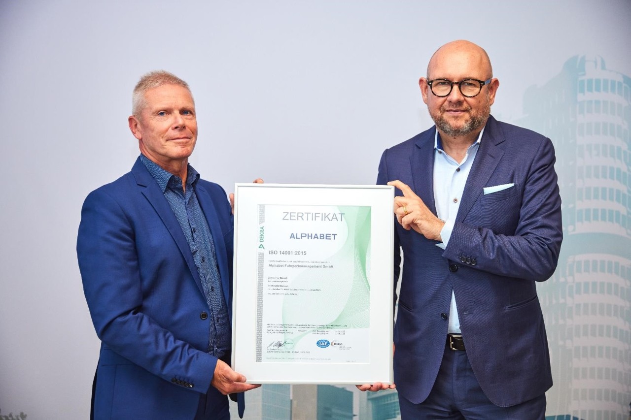 Uwe Hildinger hält ein Zertifikat für Alphabet in den Händen  