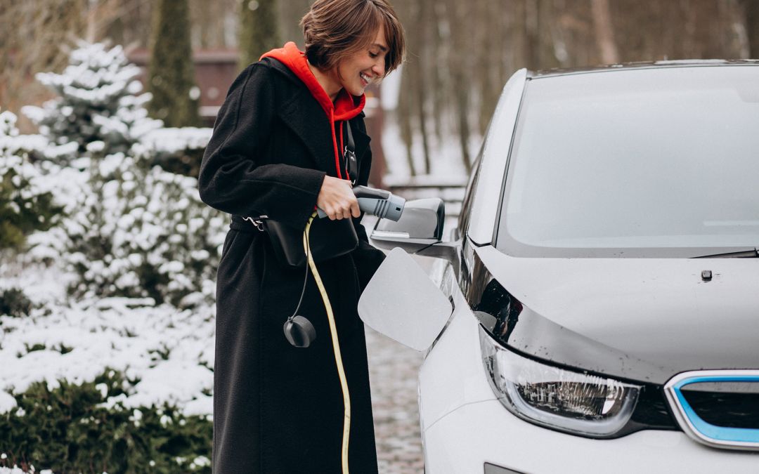 Woman charging her electric car in winter
