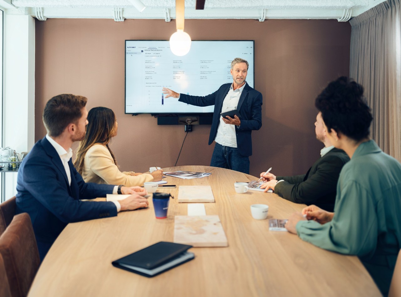 Conference room with five people.