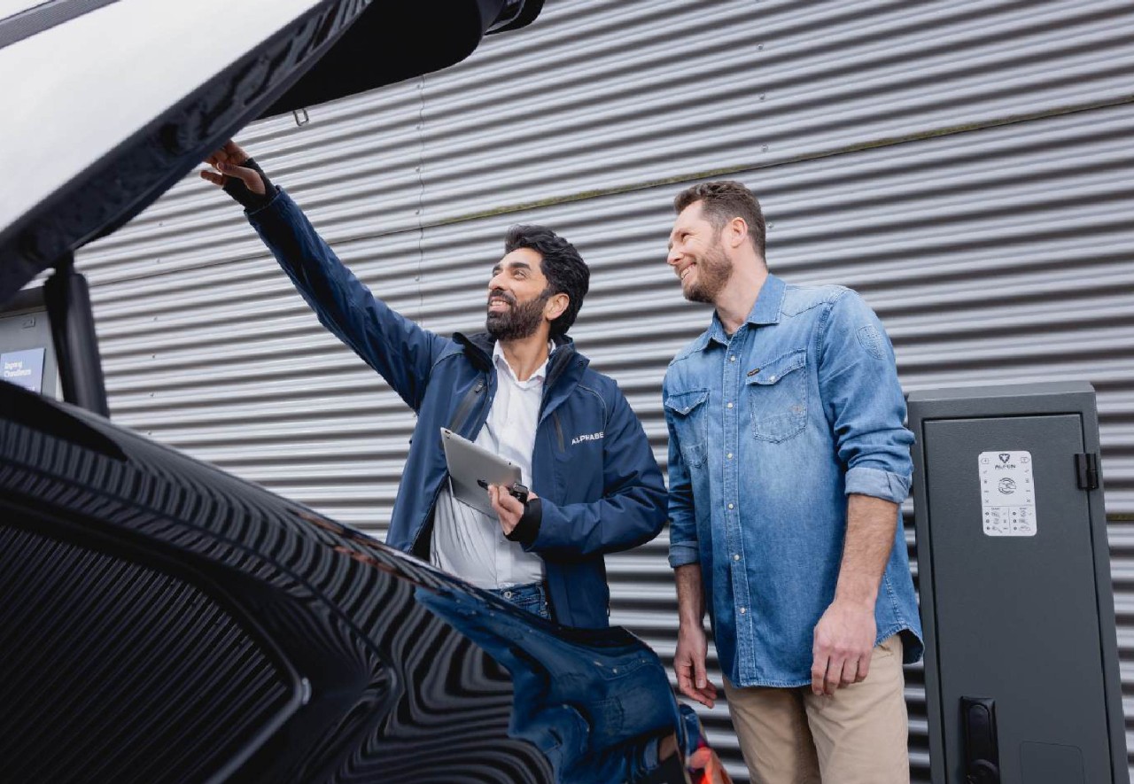 Two men looking under the car boot