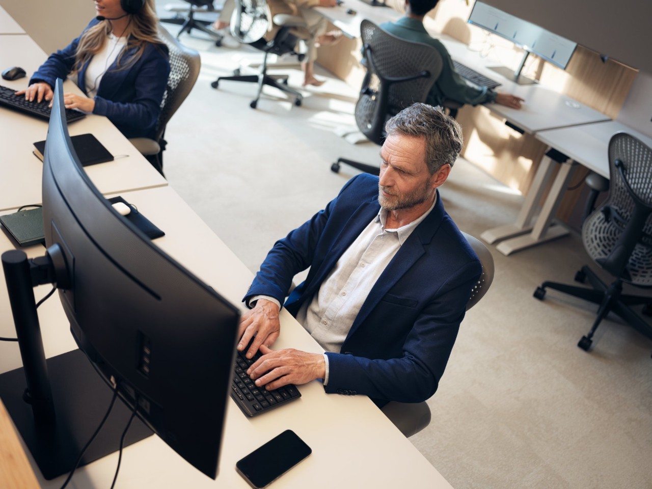 Man in a blue suit at a computer monitor.
