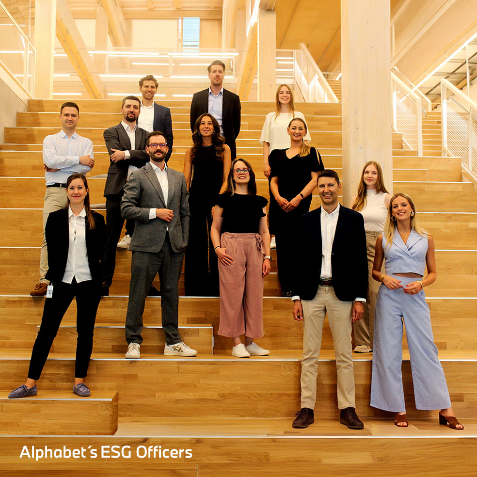 Group of Alphabet's ESG officers standing together in a bright office atrium.