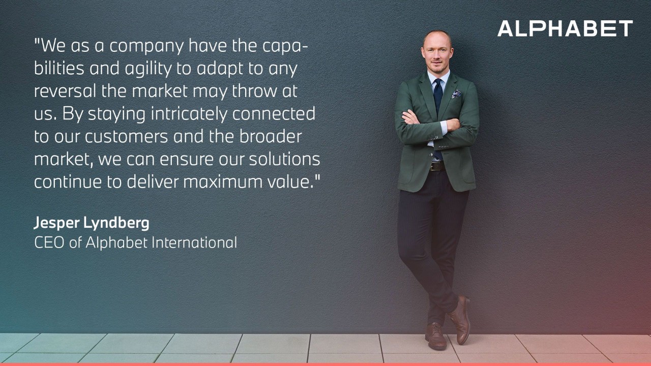 Jesper Lyndberg, CEO of Alphabet International, stands against a modern wall next to a featured quote about adaptability, customer focus, and delivering maximum value in a changing market. The image emphasizes strong leadership and corporate vision.