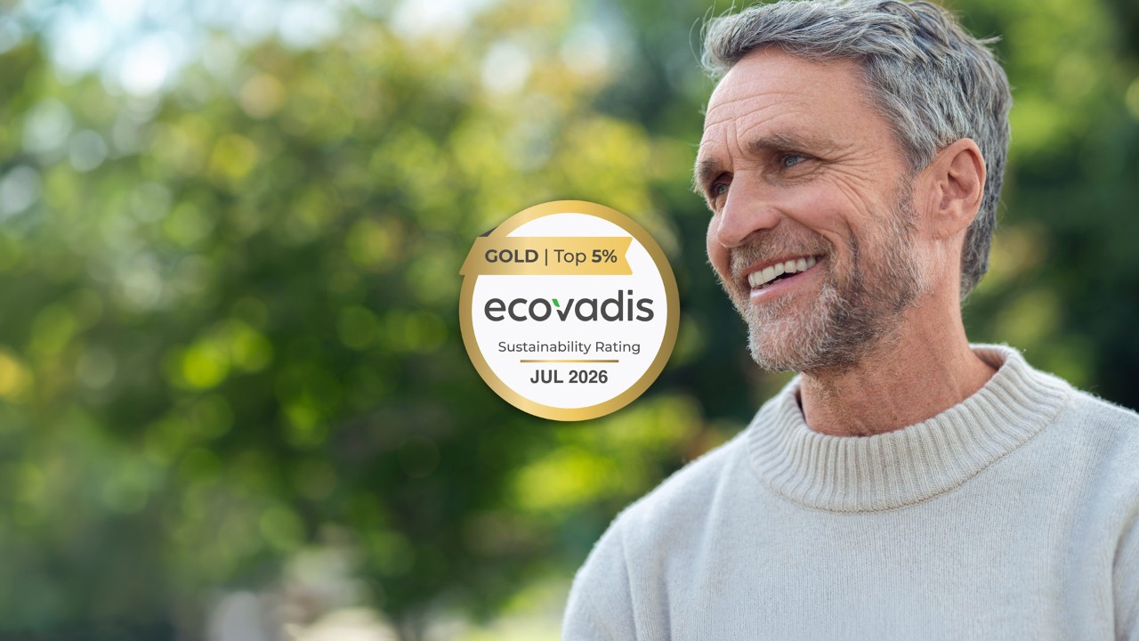 Smiling man outdoors beside a Gold EcoVadis sustainability rating badge.
