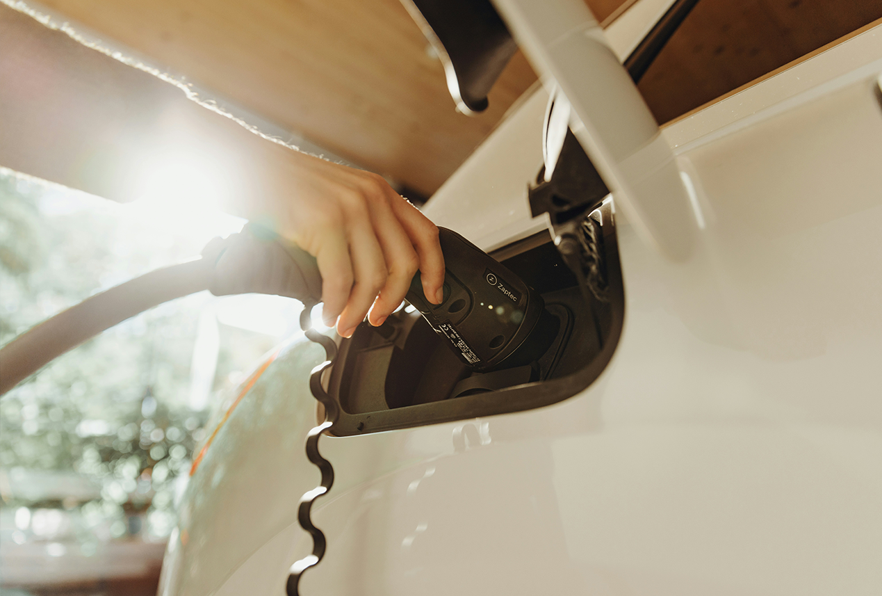 mano cargando un coche electrico