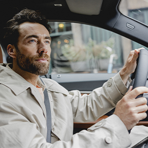 chico de ojos claros con las manos en el volante conduciendo