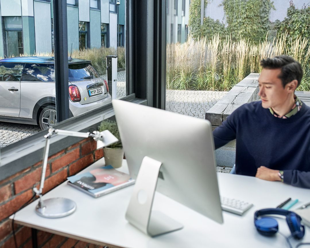 chico con un iMac y la mirada baja