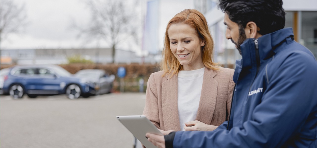 Mujer revisando contenido en su tablet junto a un asesor de Alphabet