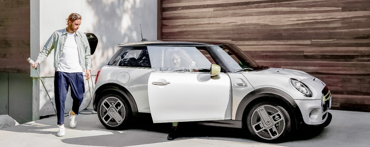 Chico rubia con coche coche blanco eléctrico