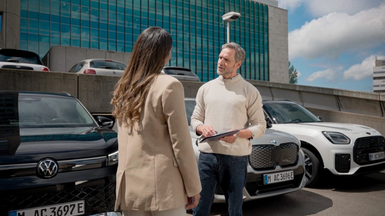 señor hablando con una chica y coches de fondo