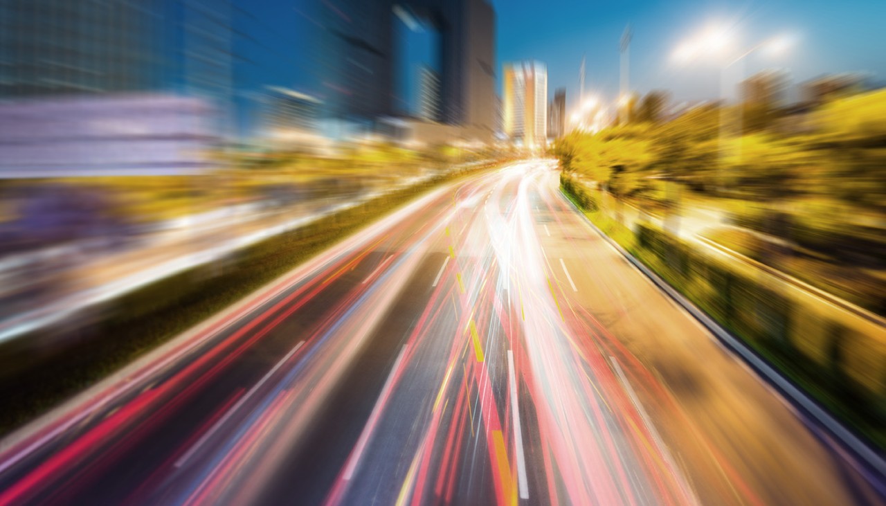 Foto borrosa de una carretera con luces y edificios altos
