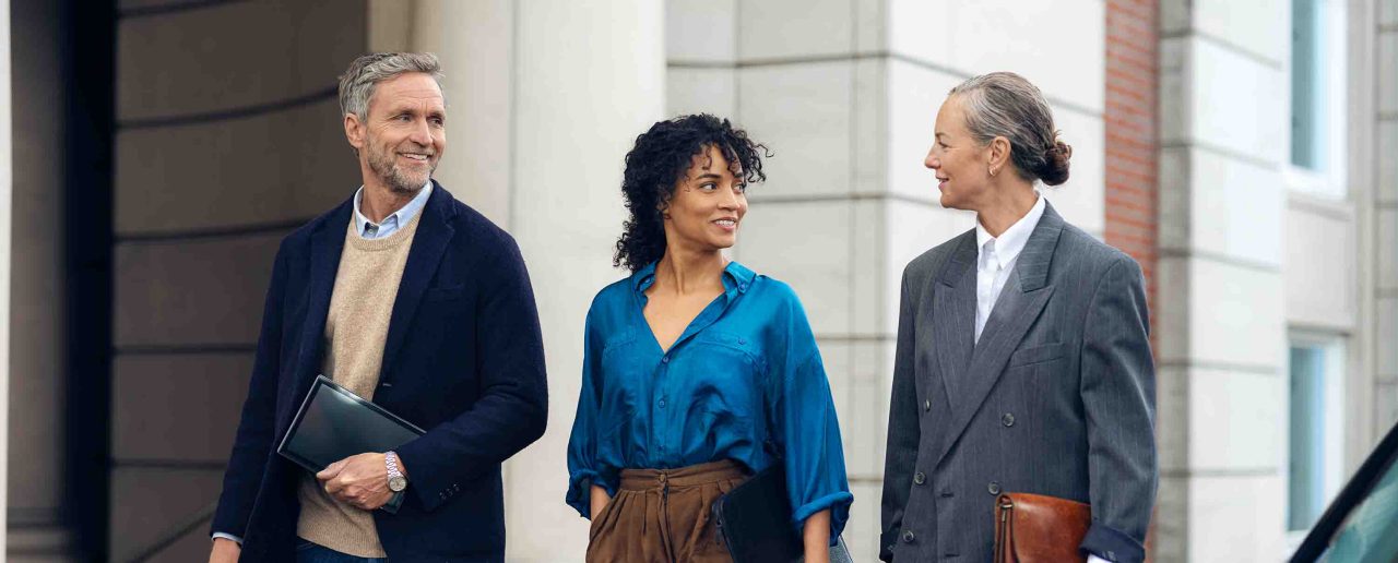 Dos señores con chica de blusa azul andando