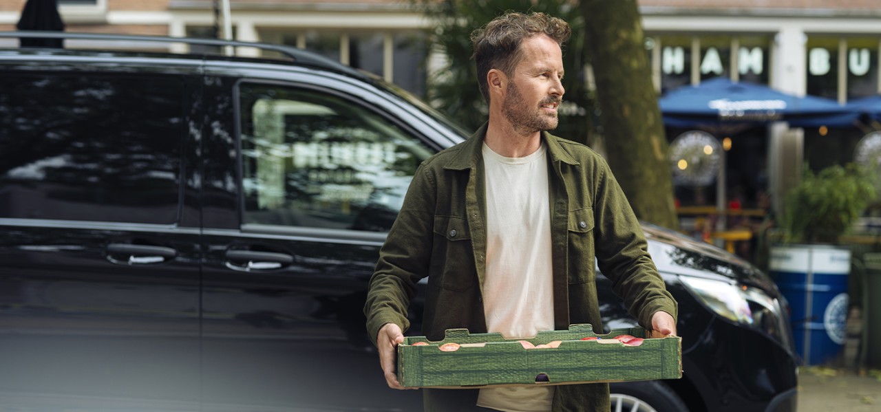 chico llevando una caja de manzanas