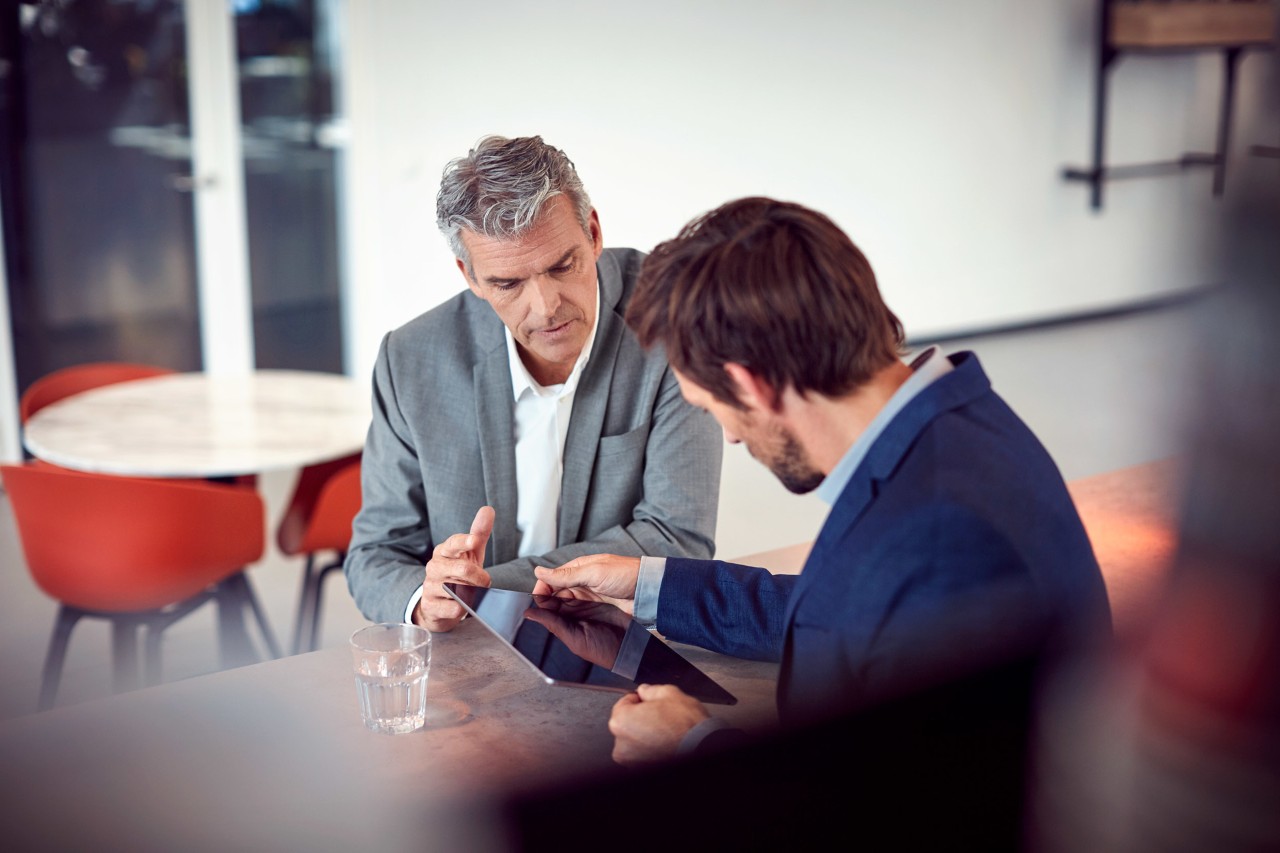 dos hombres mirando y sujetando una tablet