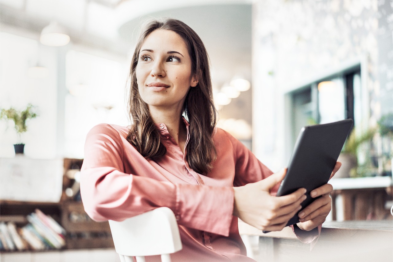 chica con blusa rosa sujetando una tablet