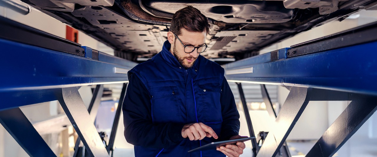 mecanico en taller mirando una tablet