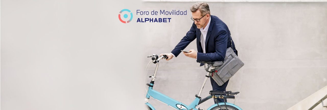 hombre sujetando una bici y mirando el movil