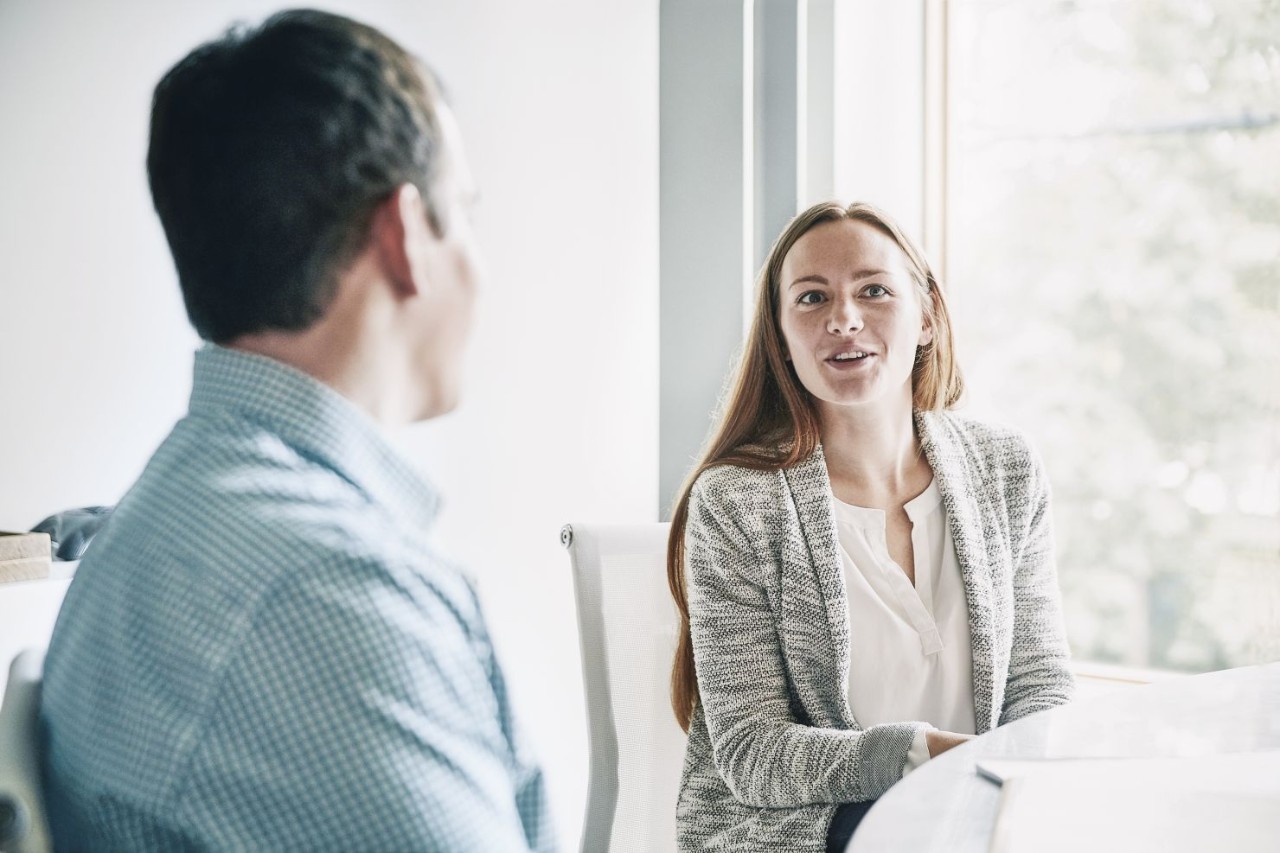 Chica con americana hablando con un hombre de camisa