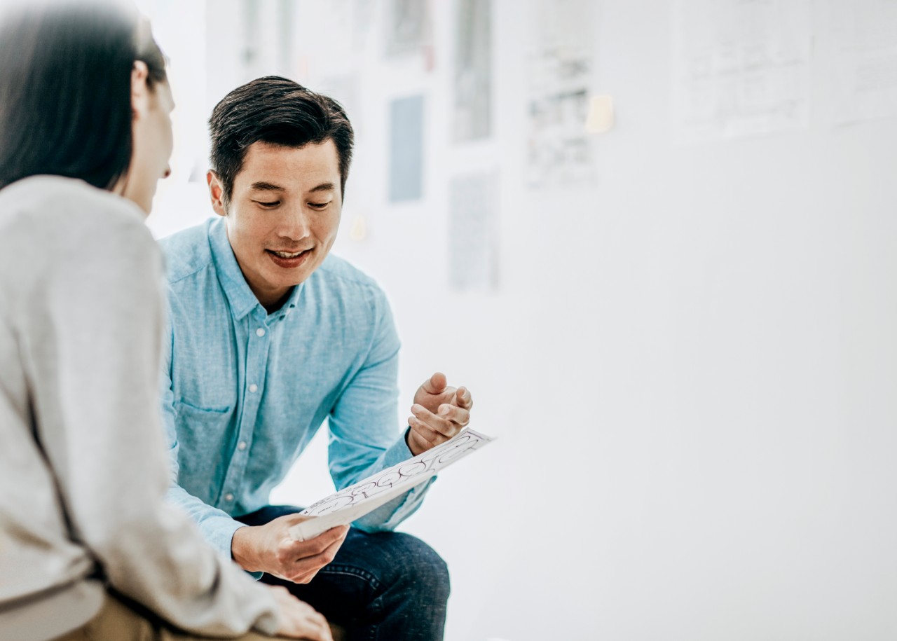 1216505484 chico explicando lo que pone en un papel a una chica