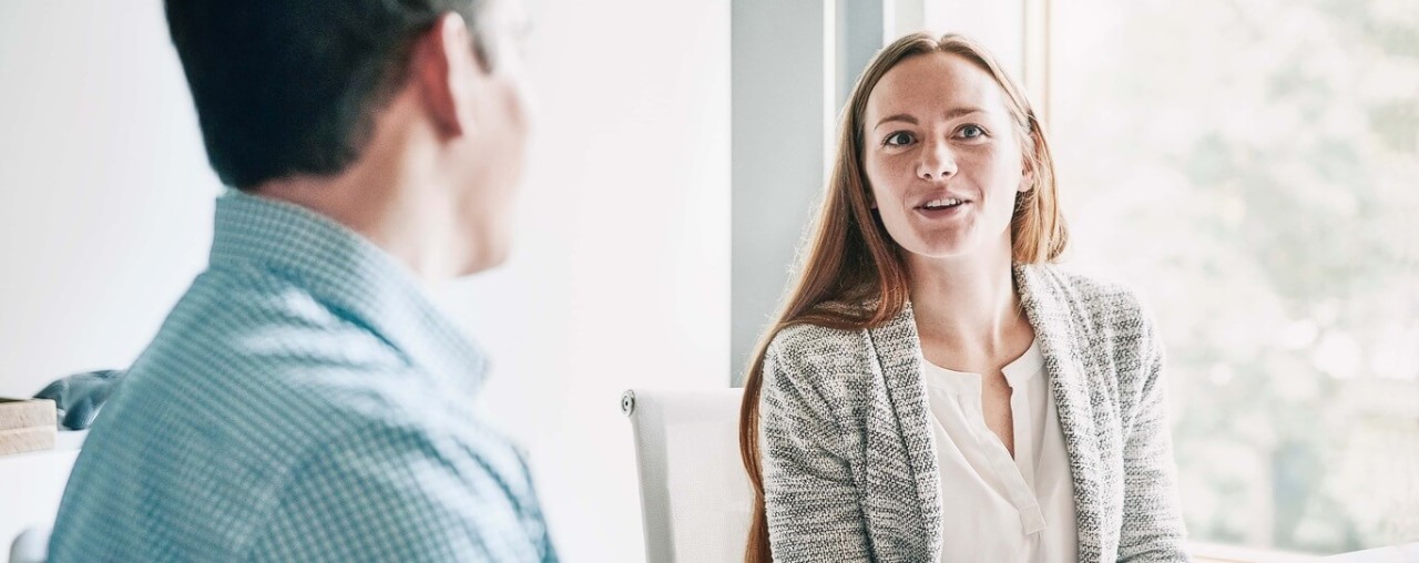 Chica con americana hbalando con chico con camisa