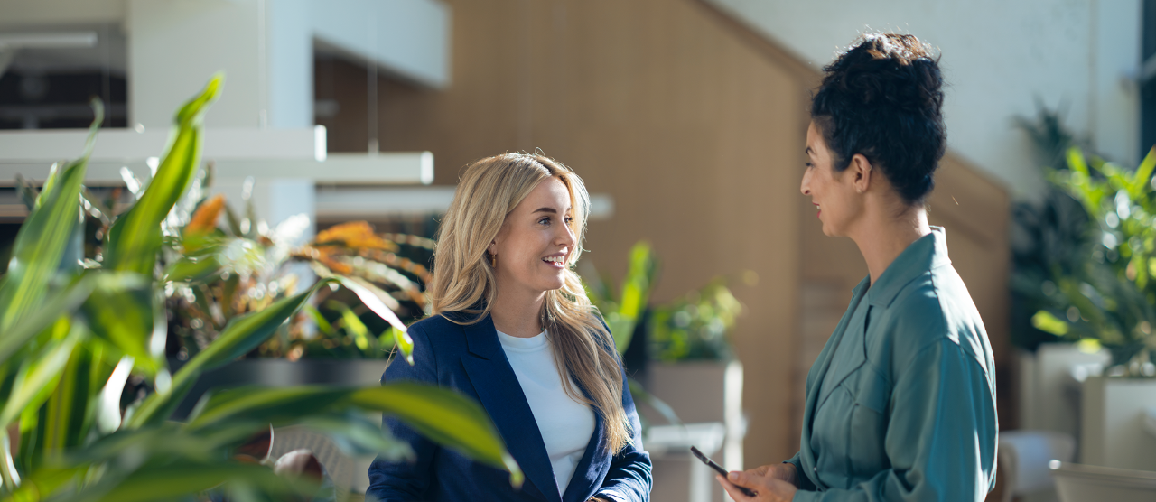 mujer rubia hablando con chica de camisa verde