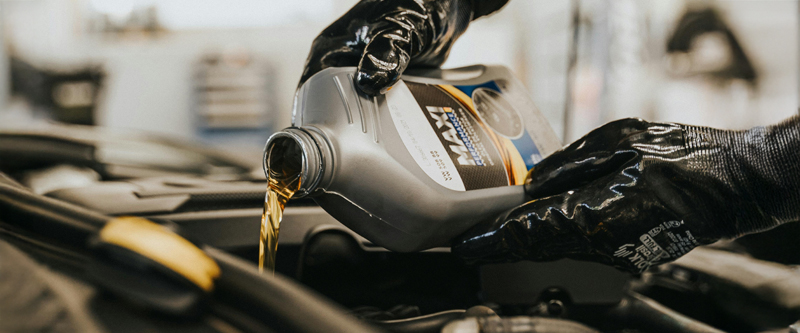 aceite de coche y unas manos con guantes negros