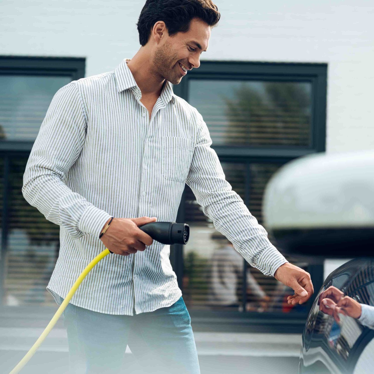 Hombre cargando su coche electrico en al aire libre. Hombre cargando su coche electrico en al aire libre.