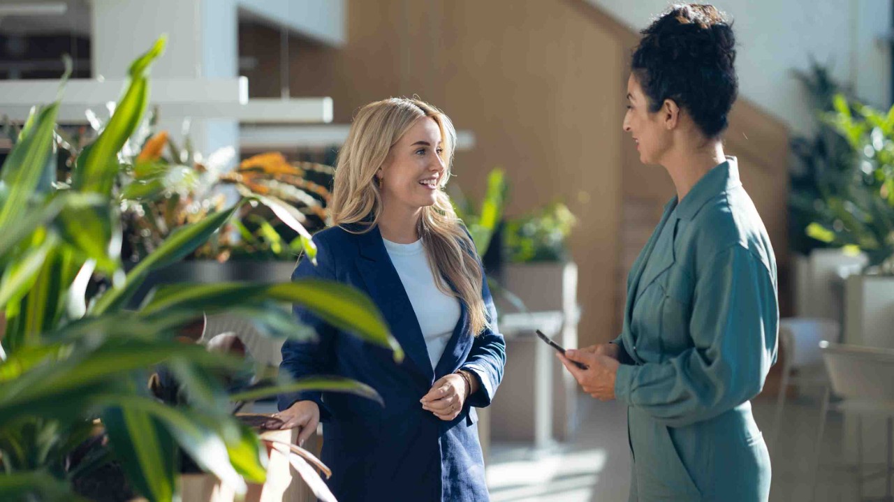 Mujer hablando con su companera tranquilamente en un patio.