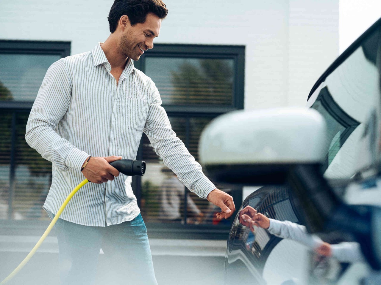 Homme qui s'apprête à brancher son véhicule électrique 