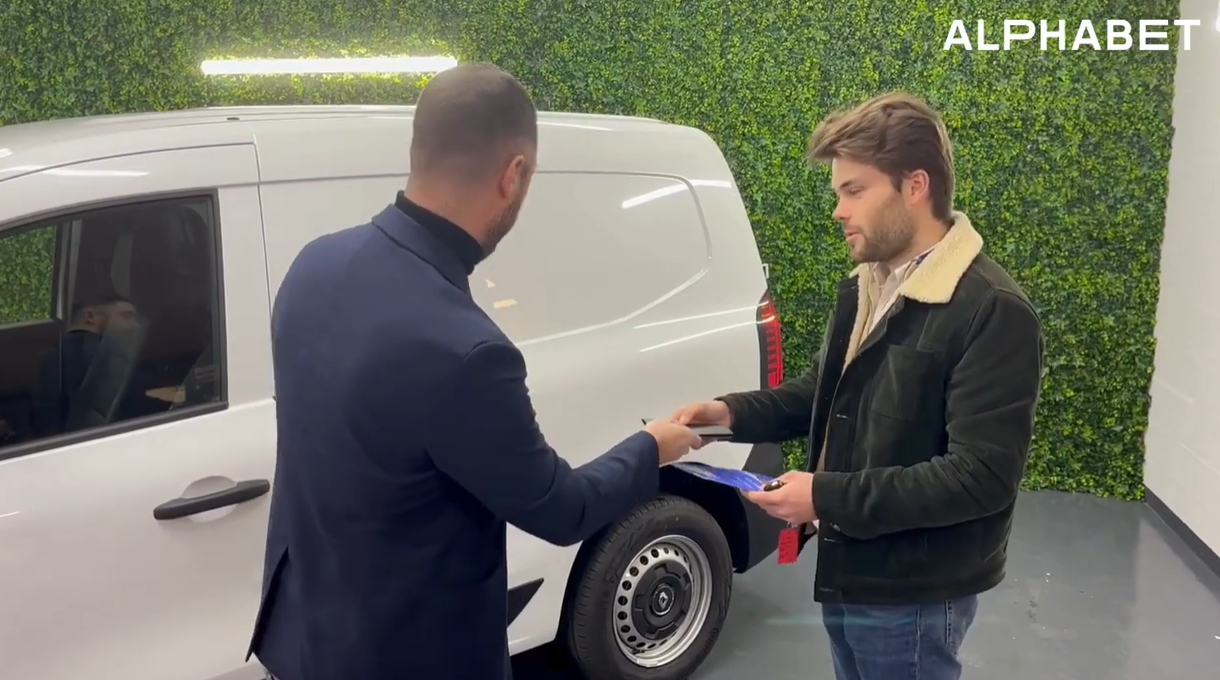 2 hommes parlent devant un véhicule utilitaire Alphabet