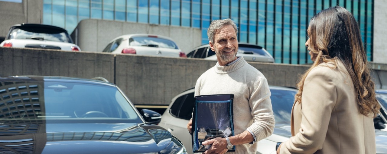 Homme et femme discutent dans parking extérieur
