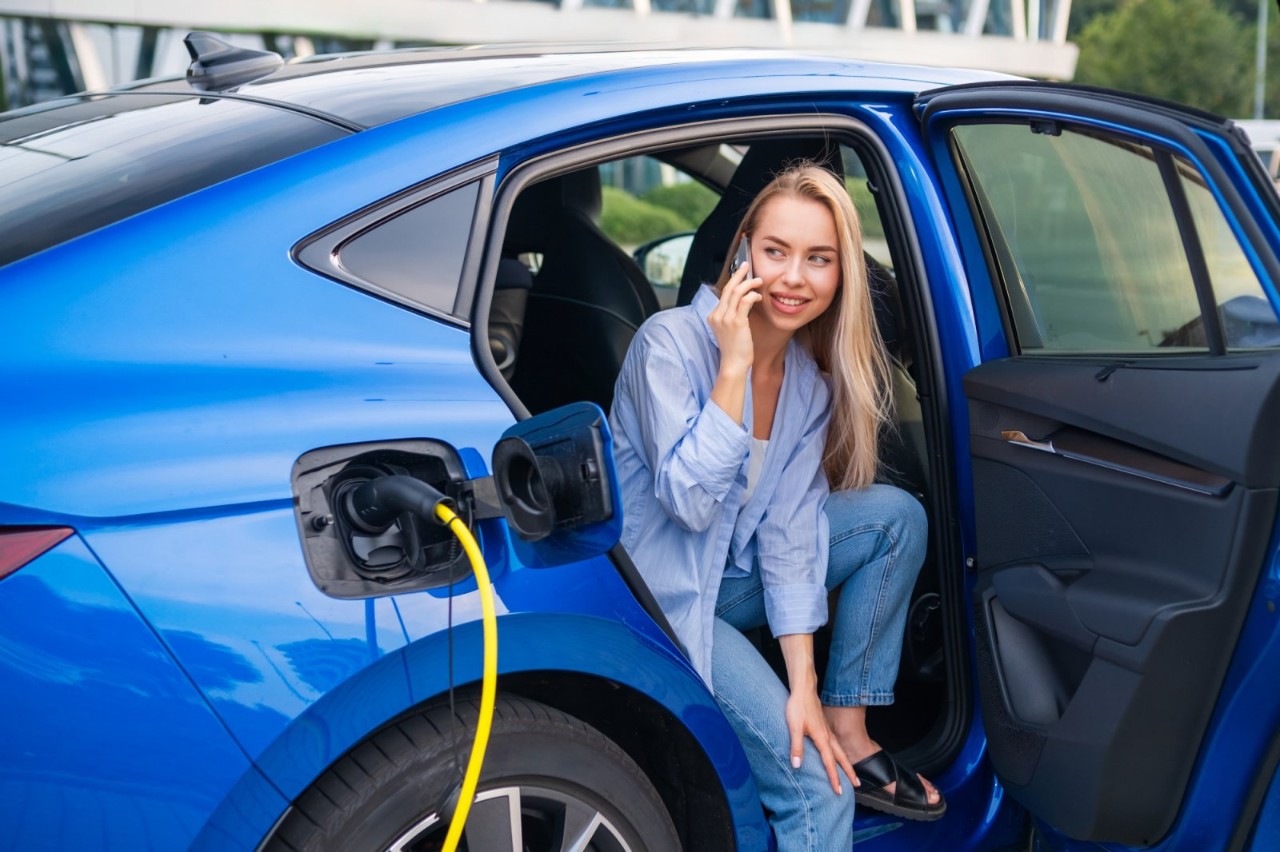 Giovane ragazza seduta in un'auto elettrica