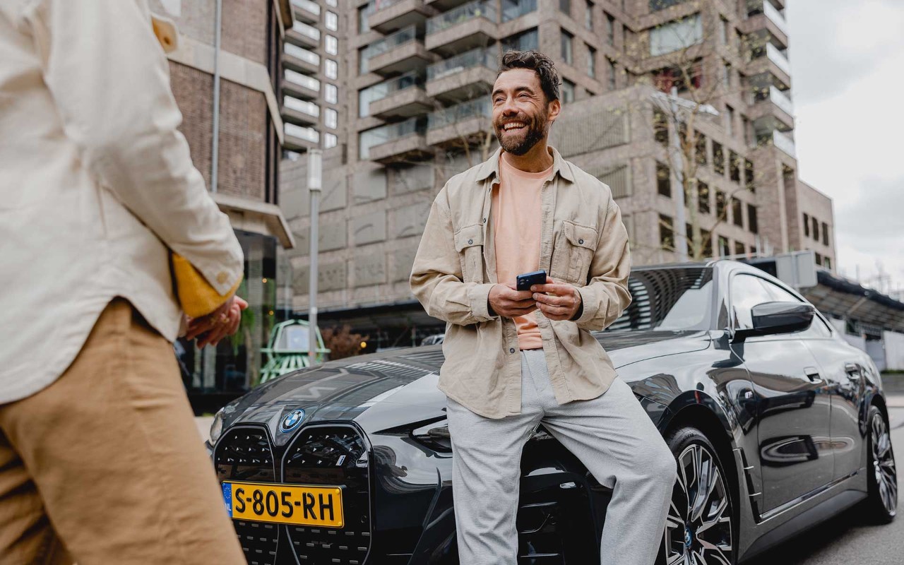Man leunt op zijn BMW