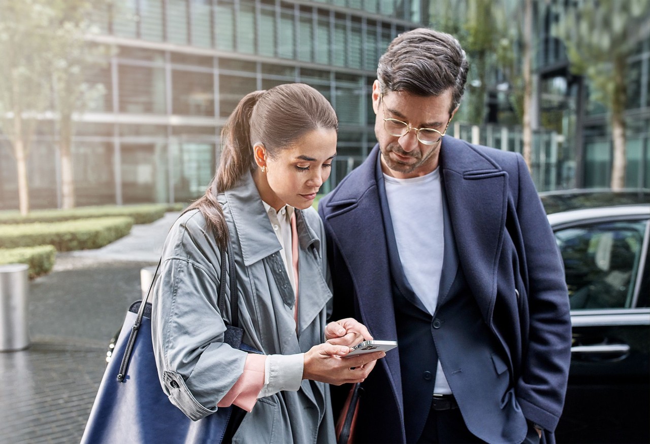 Een man en een vrouw kijken samen naar de telefoon.