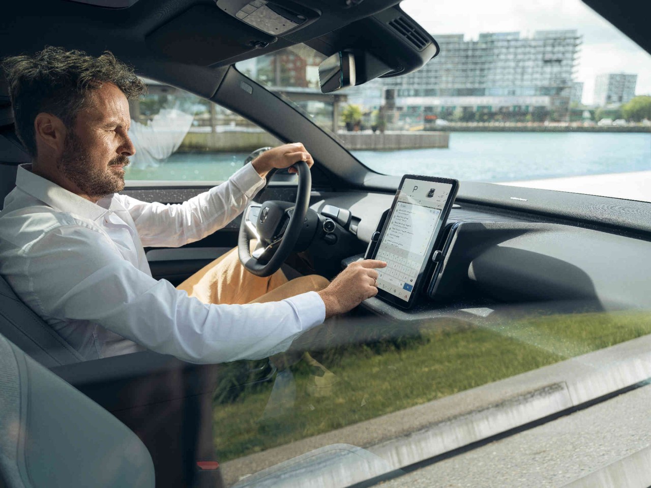 Man vult een locatie in op het scherm van zijn auto.